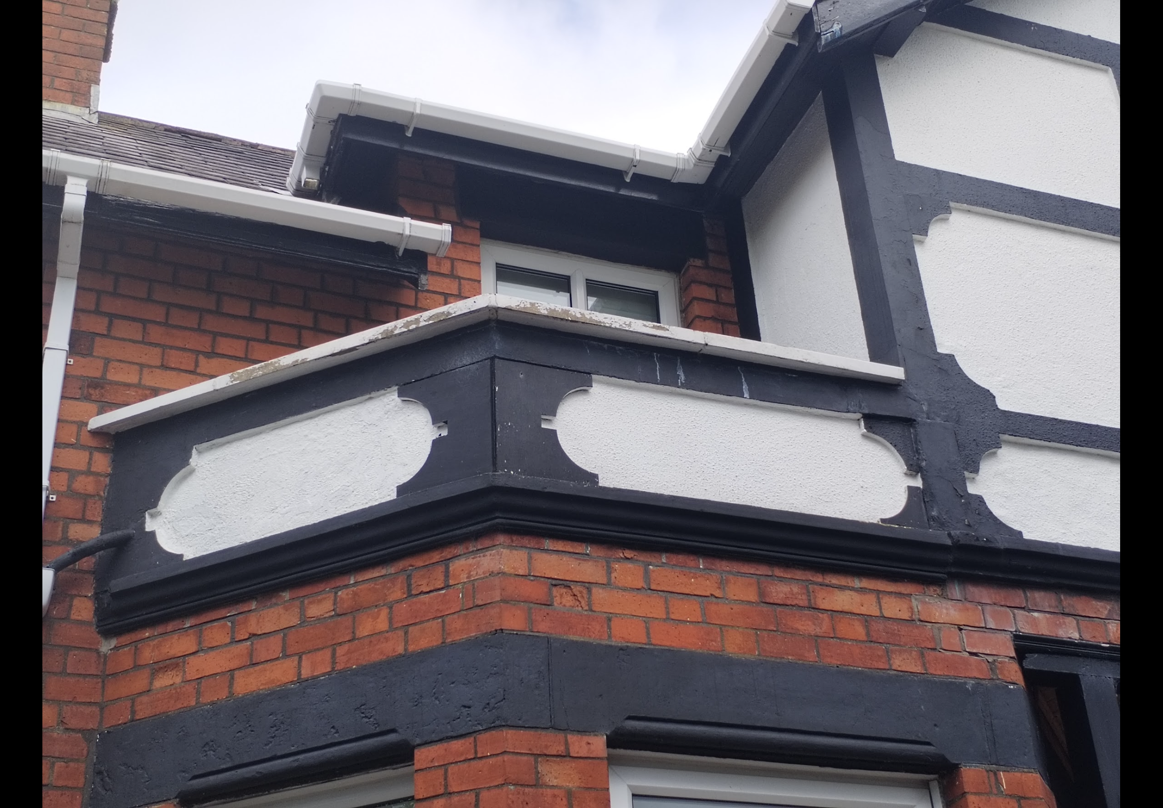 Exterior painting Bangor — decorative rendered bay and cornice with worn coatings before restoration