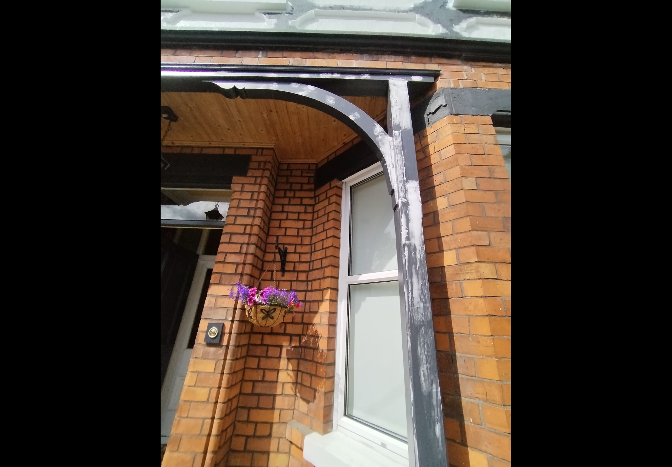 Exterior painting Bangor — close-up of porch arch and column showing peeling and deteriorated paintwork before restoration